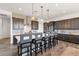 Stylish kitchen features a center island with bar seating, dark cabinets and pendants at 11249 N Blakely St, Surprise, AZ 85388