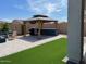 Backyard boasts an outdoor kitchen, artificial turf, a firepit and a gazebo at 11403 W Ashby Dr, Peoria, AZ 85383