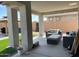 Large covered patio with comfortable seating, artificial turf, and backyard views providing an inviting outdoor living area at 11403 W Ashby Dr, Peoria, AZ 85383