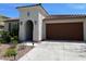 Charming single-Gathering home featuring a brown garage door, an arched entryway, and tasteful desert landscaping at 11403 W Ashby Dr, Peoria, AZ 85383