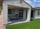 Covered patio featuring a comfortable seating area and well-manicured artificial turf creating an inviting outdoor space at 11403 W Ashby Dr, Peoria, AZ 85383