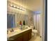Well-lit bathroom featuring a single sink vanity and a toilet with a white curtain at 11906 N 154Th N Ln, Surprise, AZ 85379