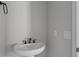 Modern bathroom features a white pedestal sink with sleek, dark fixtures, and neutral paint at 12332 W Parkway Ln, Avondale, AZ 85323