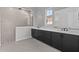 Beautiful bathroom boasts double sinks, dark cabinets, and a glass-enclosed shower at 12332 W Parkway Ln, Avondale, AZ 85323