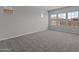 Large bedroom features plush gray carpet, bright natural light, and beautiful neighborhood views at 12332 W Parkway Ln, Avondale, AZ 85323