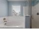 Relaxing bathroom featuring a garden tub, a window, and a glass door walk in shower at 14231 W Bronco Trl, Surprise, AZ 85387