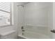Clean bathroom featuring a shower/tub combo with tile surround, window and neutral paint at 14231 W Bronco Trl, Surprise, AZ 85387