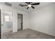 Carpeted bedroom featuring a ceiling fan, walk-in closet, and an ensuite bathroom at 14231 W Bronco Trl, Surprise, AZ 85387