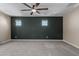 Spacious carpeted bedroom featuring a ceiling fan, two windows, and two-tone walls at 14231 W Bronco Trl, Surprise, AZ 85387