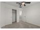Bedroom view showcasing neutral walls, carpet, closet with open door, and a ceiling fan at 14231 W Bronco Trl, Surprise, AZ 85387