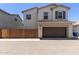 Traditional two-story home with brown shutters, a two car garage and a brick fence at 14231 W Bronco Trl, Surprise, AZ 85387