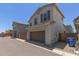 Two-story home featuring a 2-car garage, desert landscaping and a private gated entrance at 14231 W Bronco Trl, Surprise, AZ 85387