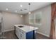 Kitchen island with white countertop, blue base, stainless steel sink, and pendant lighting at 14231 W Bronco Trl, Surprise, AZ 85387