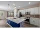 Modern kitchen with stainless steel appliances, island with sink, and white cabinets at 14231 W Bronco Trl, Surprise, AZ 85387