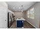 Modern kitchen featuring stainless steel appliances, white cabinets, and blue island at 14231 W Bronco Trl, Surprise, AZ 85387