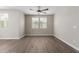 Bright living room with wood-look floors, neutral walls, ceiling fan and many windows at 14231 W Bronco Trl, Surprise, AZ 85387