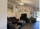 Comfortable living room featuring hardwood floors, a leather sofa, and a ceiling fan at 14922 W Port Au Prince Ln, Surprise, AZ 85374