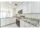 Modern kitchen with stainless steel appliances, granite countertops, and white cabinets at 15120 S Amado Blvd, Arizona City, AZ 85123