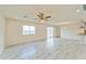Open-concept living room featuring tiled floors, ceiling fan, and sliding door access to the backyard at 15120 S Amado Blvd, Arizona City, AZ 85123