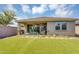 Lush artificial grass backyard featuring a covered patio, grill, and outdoor seating for relaxed outdoor living at 15133 W Moreland St, Goodyear, AZ 85338