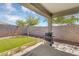 Relaxing covered patio view of the backyard with a swing set, barbecue, and artificial grass at 15133 W Moreland St, Goodyear, AZ 85338