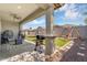 Covered patio overlooking a spacious backyard with artificial grass, swing set, grill, and comfortable outdoor seating at 15133 W Moreland St, Goodyear, AZ 85338