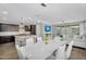 Open-concept dining area with a white table, white chairs, adjacent to the modern kitchen at 15133 W Moreland St, Goodyear, AZ 85338