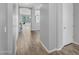 Clean and modern hallway with wood-look tile flooring, leading to a bright and open living space at 15133 W Moreland St, Goodyear, AZ 85338