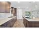 Open kitchen with stainless steel appliances, granite counters, tile backsplash, and stylish fixtures at 15133 W Moreland St, Goodyear, AZ 85338
