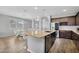 Kitchen with island seating, stainless steel dishwasher, and an archway to the dining area at 15133 W Moreland St, Goodyear, AZ 85338