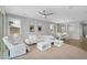 Spacious living room featuring stylish white furniture, modern decor, and views into adjacent dining area at 15133 W Moreland St, Goodyear, AZ 85338