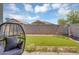 A peaceful view of the backyard featuring a swing set, trampoline, and turf from the covered patio at 15133 W Moreland St, Goodyear, AZ 85338