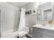 Bathroom features a tub with shower, gray vanity, and tiled walls at 17606 N 2Nd Ave, Phoenix, AZ 85023