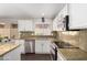 Stylish kitchen featuring stainless steel appliances, granite countertops, and white cabinetry at 17606 N 2Nd Ave, Phoenix, AZ 85023