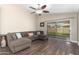 Bright living room features a ceiling fan, wood floors, and glass sliding doors to the backyard at 17606 N 2Nd Ave, Phoenix, AZ 85023
