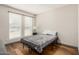 This minimalist bedroom offers two sunny windows, hardwood floors, and a comfy bed at 2062 S Emerson --, Mesa, AZ 85210
