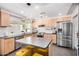 Modern kitchen with stainless appliances, a kitchen island with seating, and light wood cabinetry at 2062 S Emerson --, Mesa, AZ 85210