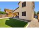 Low-maintenance backyard featuring artificial turf, a cozy covered patio, and privacy fencing at 2096 S Moccasin Trl, Gilbert, AZ 85295
