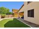 Backyard featuring artificial turf, gravel landscaping, and a cozy covered patio with outdoor seating at 2096 S Moccasin Trl, Gilbert, AZ 85295
