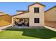 Landscaped backyard featuring lush artificial turf, a covered patio, and stylish outdoor seating area at 2096 S Moccasin Trl, Gilbert, AZ 85295