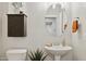 Charming powder room with a pedestal sink, decorative cabinet, and textured walls, offers a stylish space at 2096 S Moccasin Trl, Gilbert, AZ 85295