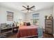 Cozy bedroom with rustic decor, including a fireplace, ceiling fan, and comfortable bedding for relaxation at 2096 S Moccasin Trl, Gilbert, AZ 85295