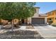 Charming two-story home featuring a two-car garage, landscaped front yard, and mature tree at 2096 S Moccasin Trl, Gilbert, AZ 85295