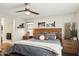 Comfortable main bedroom with a wooden headboard, ceiling fan, and natural light at 2096 S Moccasin Trl, Gilbert, AZ 85295