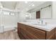 Modern bathroom with a double sink vanity, barn door mirror, and tiled shower-tub combination at 225 W Winged Foot Rd, Phoenix, AZ 85023