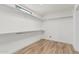 Walk-in closet with wood-look floors, shelving and a small window at 225 W Winged Foot Rd, Phoenix, AZ 85023