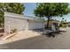 Contemporary home featuring a two car garage and desert landscaping with a mature tree at 225 W Winged Foot Rd, Phoenix, AZ 85023