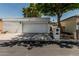 Bright, white stucco home exterior featuring a two car garage with mature landscaping and trees at 225 W Winged Foot Rd, Phoenix, AZ 85023