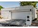 Modern home exterior with a two car garage, mature landscaping, and an iron gate entry at 225 W Winged Foot Rd, Phoenix, AZ 85023
