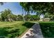 Lush green space with meandering walkways and mature trees create a serene environment for residents at 225 W Winged Foot Rd, Phoenix, AZ 85023